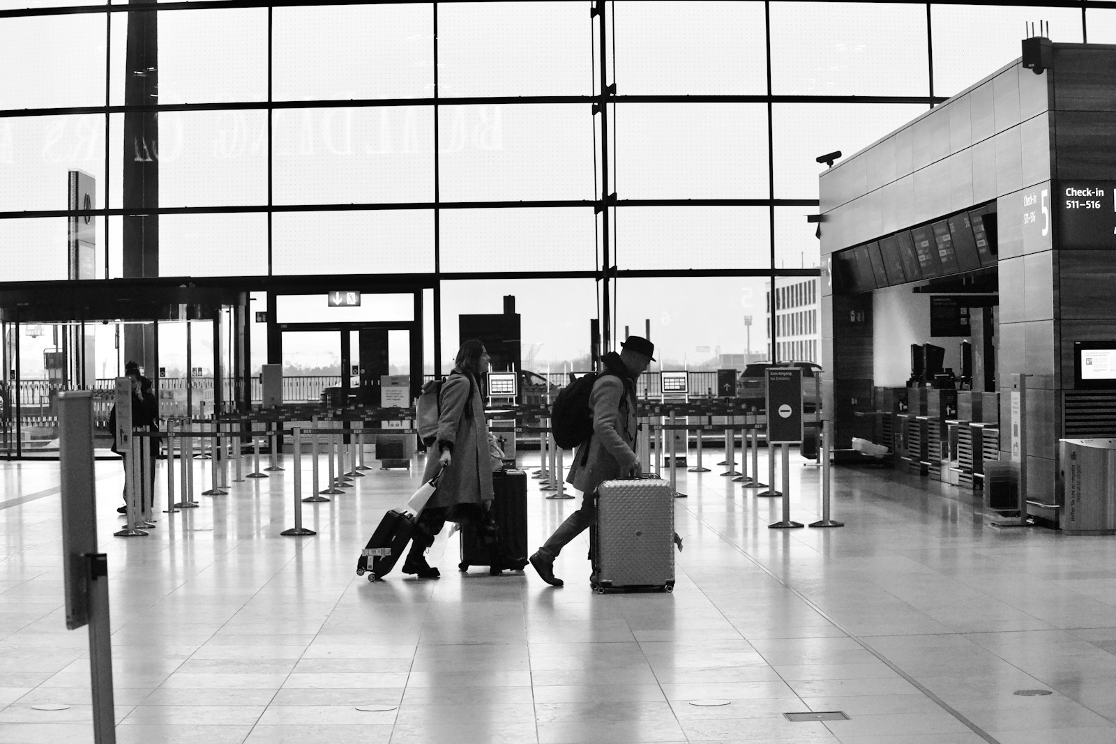 Travellers moving through an airport terminal with hand luggage